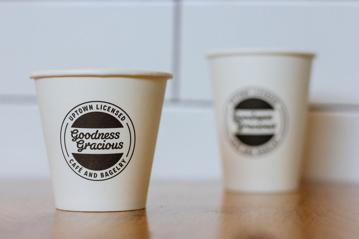 Takeaway cups printed 'Uptown Licensed · Cafe and Bagelry', 2014